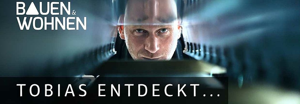 Mann schaut zwischen Stahlteile durch