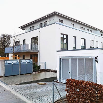 Außenansicht eines Wohnkomplexes mit Einfahrt einer Tiefgarage